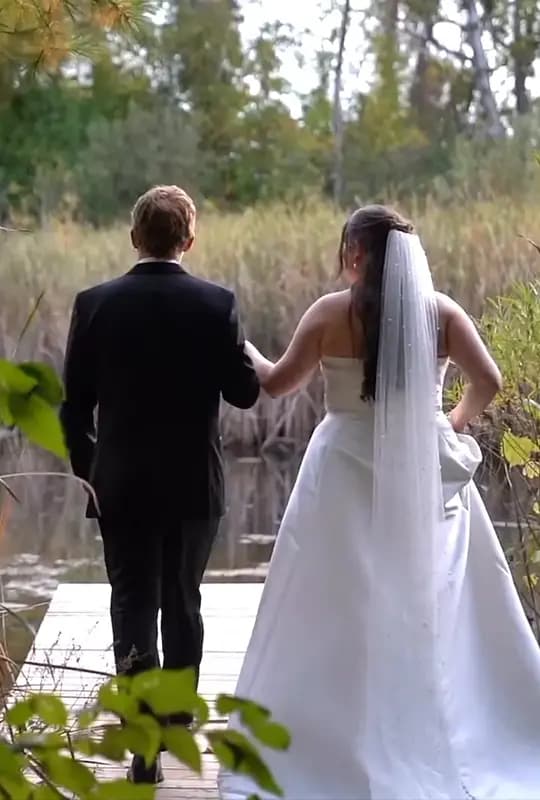 Olivia & Jacob facing away from the camera as they walk out for a romantic moment on the dock.