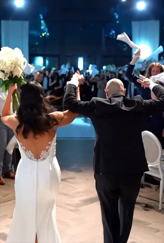 Yasmin & Michael from behind,cheering as they run into their reception hall during their grand entrance.